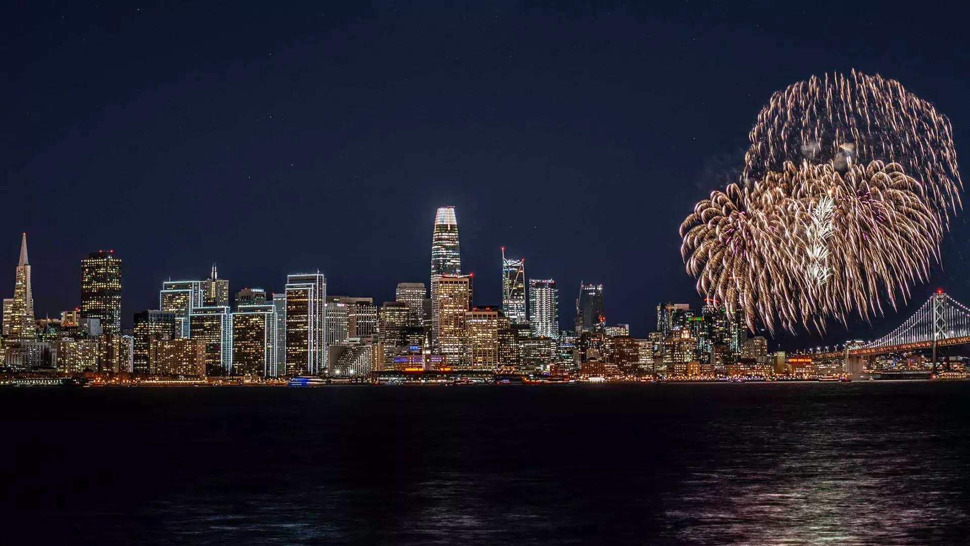 Fireworks explode over the San Francisco city skyline.