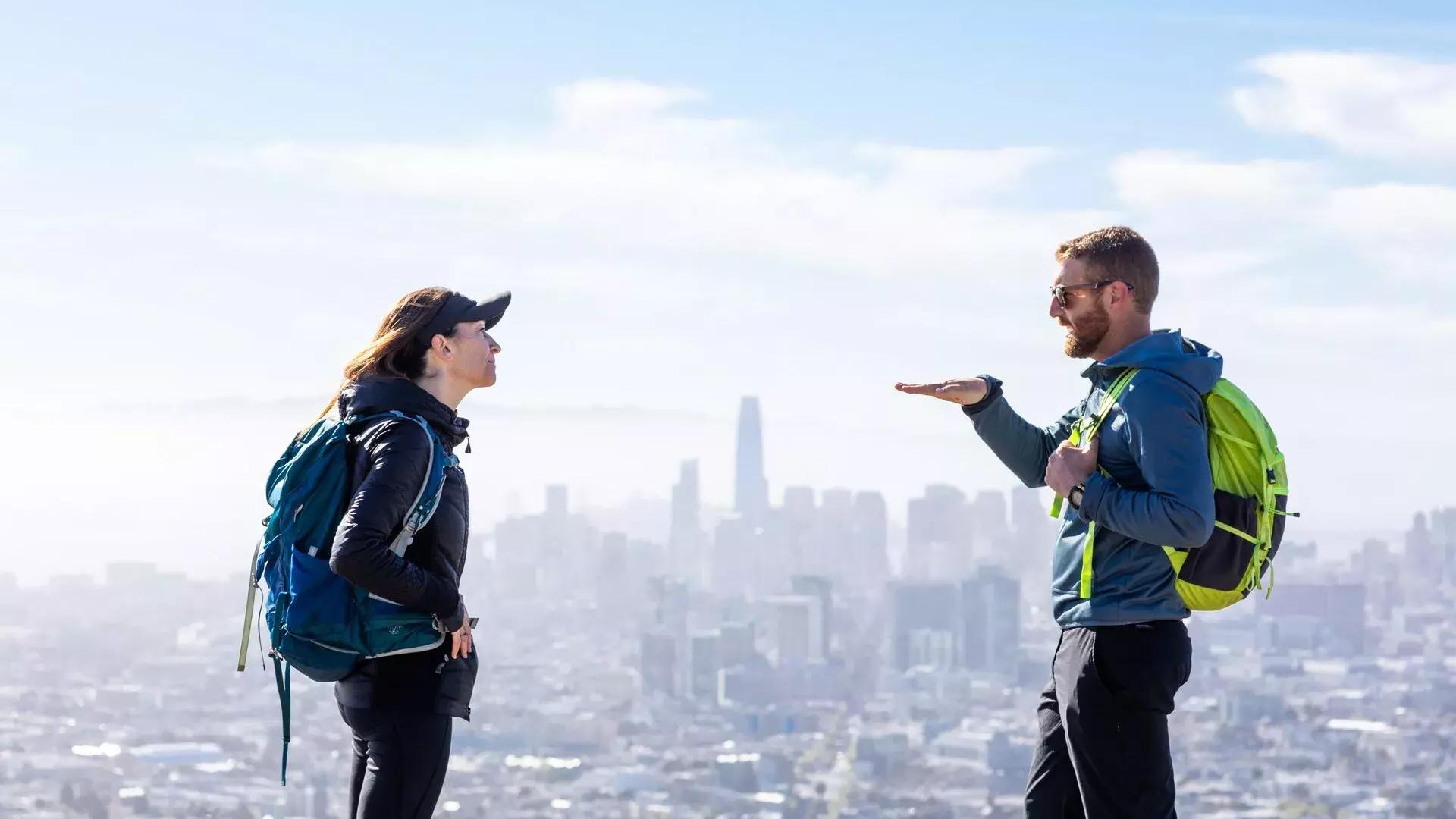 Excursionistas conversando con el horizonte de San Francisco a lo lejos