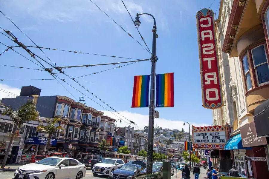 O bairro Castro, em São Francisco, com a placa do Teatro Castro e bandeiras arco-íris em primeiro plano.