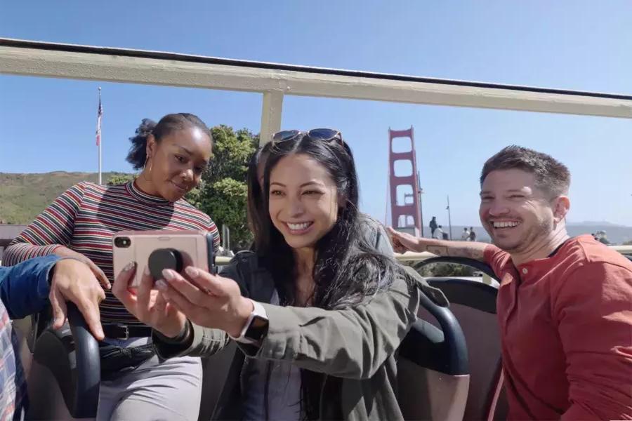 A group of visitors take a selfie on a bus tour near the Golden Gate Bridge. San Francisco, CA.