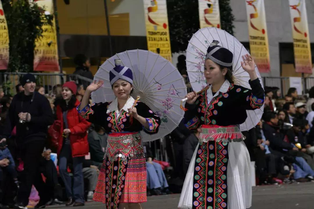 Two women in traditional dress walk in the San Francisco Chinese New Year celebration parade.