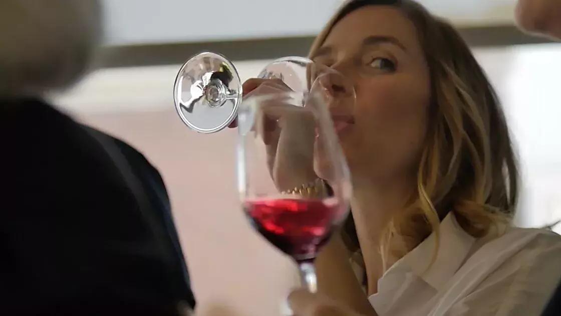 一个金发女人穿着一瓶红葡萄酒.